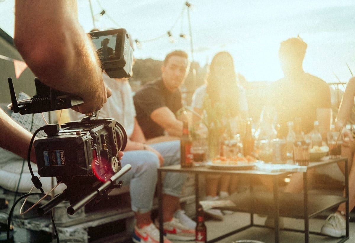 Filmkamera vor dem Team beim Apéro im Abendlicht